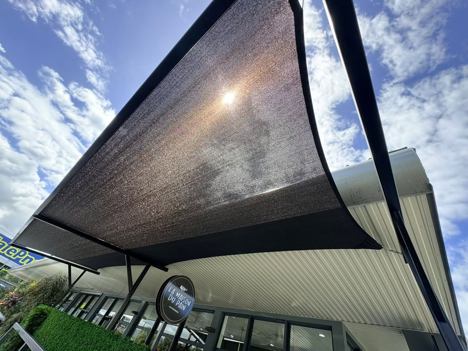 Voile d'ombrage tendue au-dessus de la terrasse de La Maison du Pain